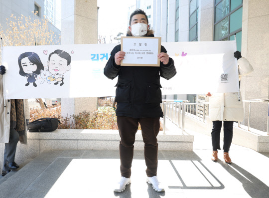 윤석열 국민의힘 대선후보의 부인 김건희 씨의 팬클럽인 '건사랑' 이승환 대표가 3일 서울 마포경찰서에 더불어민주당 선거대책위원회 최민희 미디어특보단장을 명예훼손 혐의로 고발하기에 앞서 포즈를 취하고 있다. <연합뉴스>